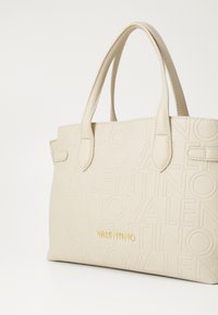 Beige leather handbag with embossed "Valentino" branding, two top handles, and a structured rectangular shape. Gold hardware accents.