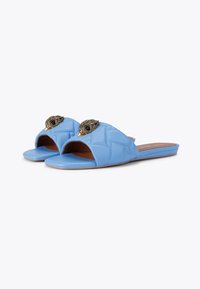 Sandali slide in pelle blu con design intrecciato, dotati di hardware decorativo a forma di uccello sulla parte superiore. Suola piatta con punta aperta.