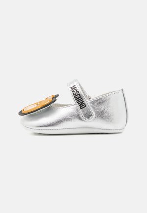 Zapato de bebé plateado con correa Moschino y gran detalle de cara de oso de peluche en la parte delantera, diseñado para bebés.