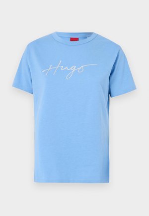 Lyseblå bomulds T-shirt med korte ærmer. Har et hvidt kursiv "Hugo" logo over brystet. Rund hals og standard pasform.