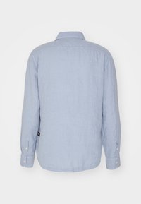 Camicia a maniche lunghe di colore azzurro chiaro realizzata in lino. Presenta colletto e polsini con bottoni, un orlo dritto e una trama liscia.