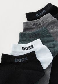 Zestaw pięciu skarpet w kolorach czarnym, szarym, ciemnozielonym, jasnoszarym i białym, z prążkowanym wzorem i logo "BOSS" na mankietach.