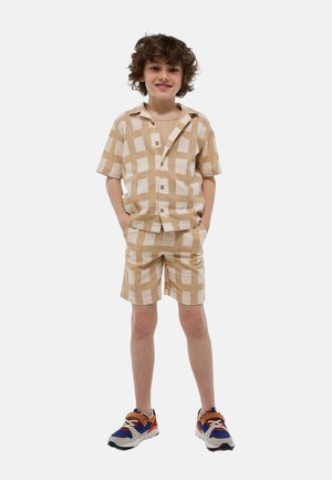 Chemise marron clair à manches courtes etShorts assortis avec un motif à carreaux. La tenue présente une coupe décontractée et une fermeture à boutons.