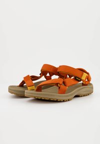 Sandalias exteriores naranjas con correas ajustables, suelas de goma y plantilla texturizada. Presenta un diseño duradero y ligero.