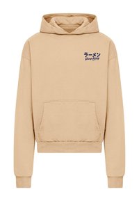 Sudadera beige con un bolsillo frontal, que presenta un gráfico de texto en japonés e inglés en el lado izquierdo del pecho. Tejido suave, corte relajado.