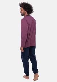 Langsleeve maroon top met een gestructureerd patroon, gecombineerd met marineblauwe, taps toelopende broek. Casual loungewear met een ontspannen pasvorm.