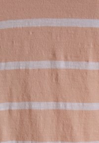 Tecido de algodão em pêssego claro com três riscas brancas horizontais. Superfície texturizada com variações subtis para adicionar dimensão.