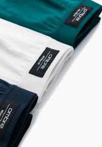 Trois paires de boxers sans couture en marine, turquoise et blanc. Chacune possède une taille douce avec une étiquette logo noire. Texture en tissu de coton.