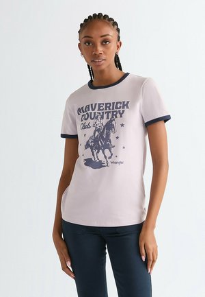 Jasnoróżowy t-shirt z granatowymi lamówkami, na którym znajduje się grafika jeźdźca na koniu oraz napis „Maverick Country Club”. Miękki materiał, krótkie rękawy.