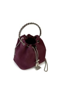 Bolso tipo bucket de ante en burdeos profundo con un asa de cadena plateada, cierre de cordón y acentos metálicos. Presenta una textura suave.