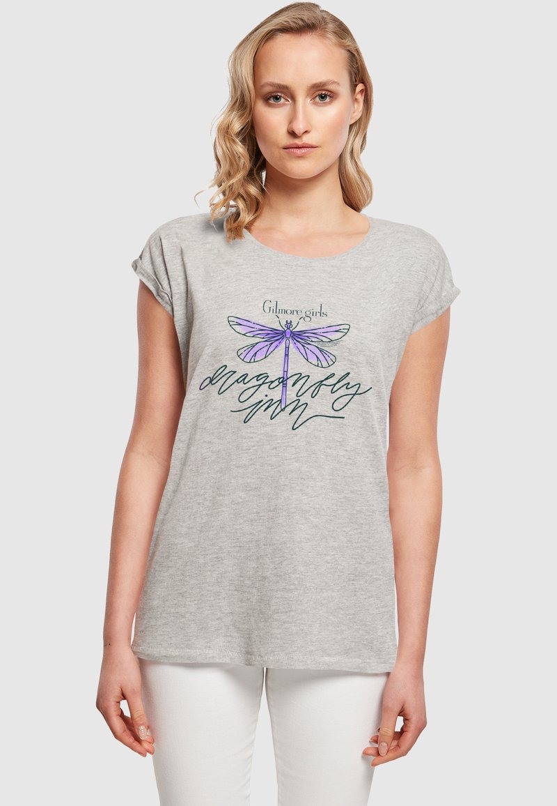 Graues T-Shirt mit kurzen Ärmeln, das ein Libellenmotiv in Lavendel und Grün zeigt, mit dem Text "Gilmore Girls Libellenmarmelade" darunter.