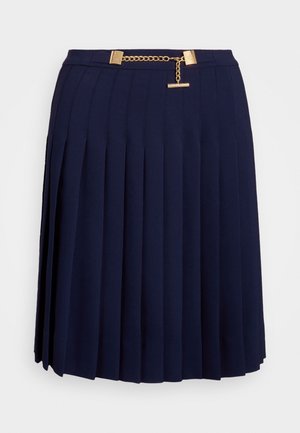 Marineblauwe geplooide rok met een gouden kettingriem met rechthoekige gespen en een T-bar detail aan de tailleband.