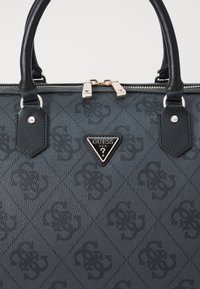 Borsa a tracolla nera con texture, caratterizzata da un motivo a diamante, accessori in oro, manici superiori e un logo triangolare ben in vista sulla parte anteriore.