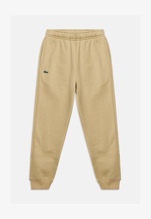 Beige bomulds joggingbukser med elastisk linning, ribstrikkede manchetter, sidelommer og en lille broderet grøn krokodille-logo på venstre lår.