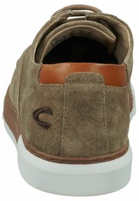 Braune Wildleder-Sneaker mit einer Leder-Fersenpartie, weißer Gummisohle und einer gesteppten Akzentuierung entlang der Unterseite. Der Rückansicht zeigt die Schnürung und das Markenlogo.