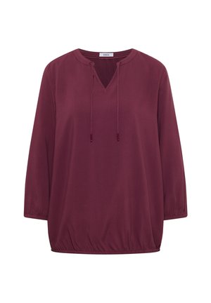 Blouse bordeaux à manches longues avec ourlet élastique, col en V avec cordons à nouer et col rond, en tissu texturé.