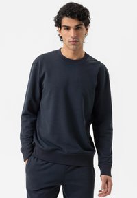 Marineblauwe sweatshirt van zacht materiaal, met een ronde hals, lange mouwen en geribbelde manchetten en onderrand, gecombineerd met bijpassende joggers.