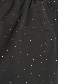 Black fabric featuring a textured surface with small, silver dot patterns. Includes a single pocket on the side.