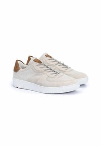 Helle beigefarbene Sneakers aus einer Mischung aus strukturiertem Wildleder und Mesh-Materialien, grauen Schnürsenkeln und einer weißen Gummisohle mit roten Akzenten.