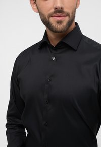 Zwarte formele shirt met een gladde stoftextuur, kraagdesign en voorknopsluiting, met zwarte knopen en een slimfit snit.