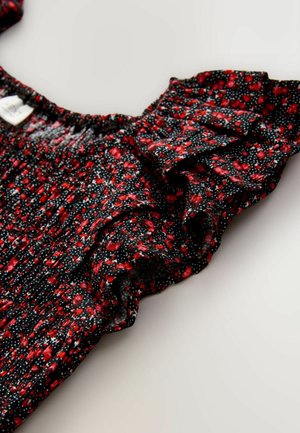 Must kangas punaste ja valgete täppidega lillemustriga. Omab voltidega varrukaid ja kogutud kaelust. Pehme tekstuur.