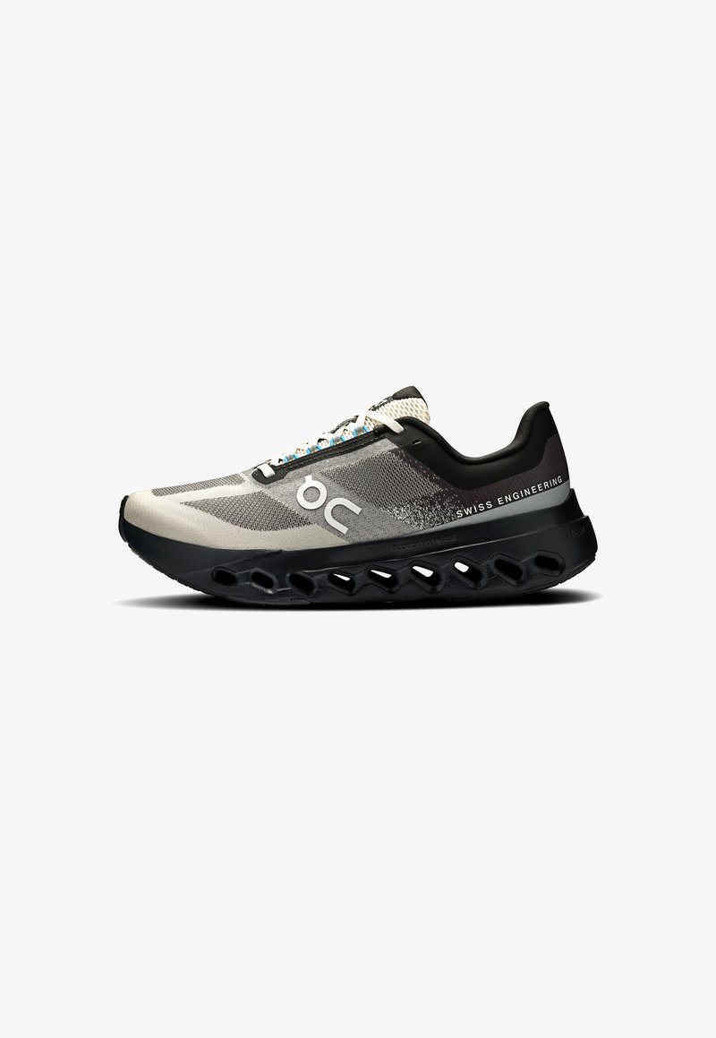 Chaussure de course avec une tige en mesh gris léger, une semelle en caoutchouc noir et un design découpé unique pour un amorti, avec des lacets bleus et blancs.