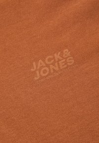 Roodkleurig katoenen T-shirt met een gladde textuur en een subtiele reliëflogo met de tekst "JACK & JONES CORE NINE ZERO EST. 1990."