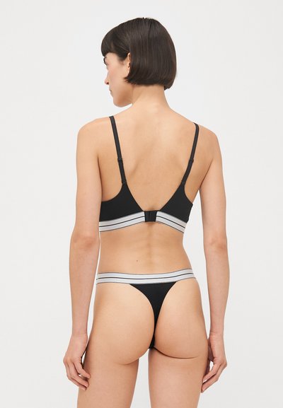 Black bra and thong set featuring a smooth texture, adjustable straps, and contrasting gray stripes on the bands. Back closure visible.