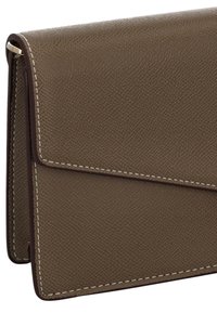 Bruine leren portemonnee met een textuur, klepsluiting, witte stiksels en een gladde donkerbruine rand. Compact, rechthoekig ontwerp.