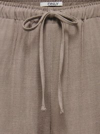 Pantalon en tissu texturé taupe avec taille élastique et cordon noué, étiqueté "ONLY" au centre du dos.