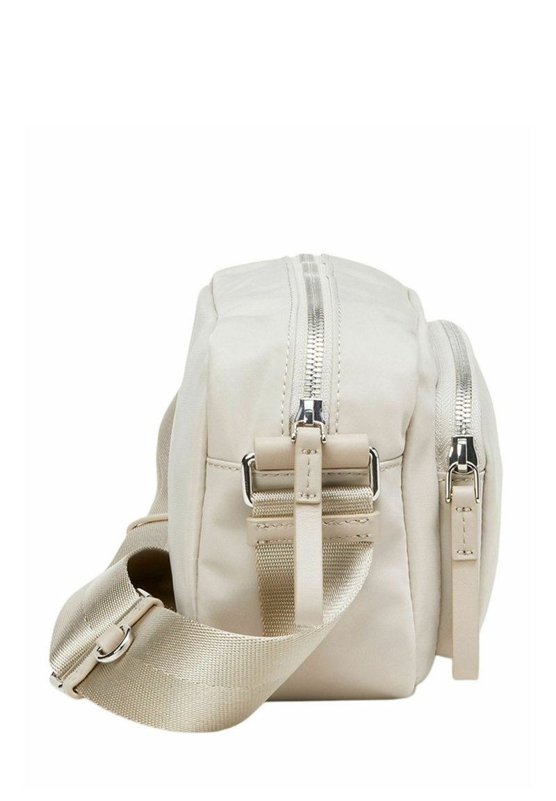 Beżowa, prostokątna torba wykonana z gładkiego materiału syntetycznego, z dwoma zamkami błyskawicznymi i regulowanym materiałowym paskiem. Zawiera akcenty metalowe.