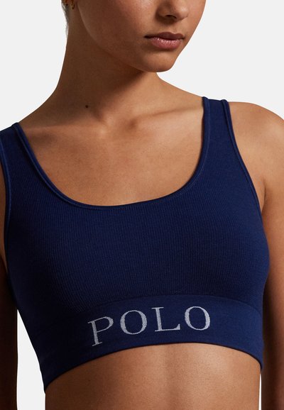 Námořnicky modrý žebrovaný bralet s širokým pruhem s nápisem "POLO" v světle šedé barvě. Elegantní, elastický materiál s přiléhavým střihem.