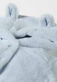 Hoodie en velours bleu clair avec des oreilles d'ours, présentant une surface douce et texturée ainsi qu'une coupe ample pour le confort. Tissu extensible autour du visage.