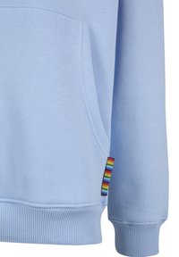 Light blue sweatshirt sleeve and pocket with ribbed cuff and hem, featuring a small rainbow-striped fabric tag near the pocket seam.