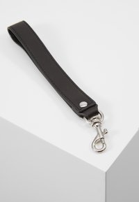 Svart läderrem med en silverfärgad metallklämma, med en slät yta och nitar som dekoration, utformad för att fästa föremål på ett säkert sätt.