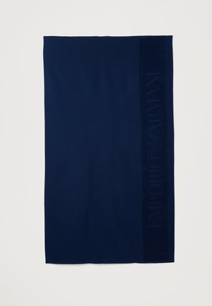 Donkerblauw rechthoekig stof met een subtiel reliëf verticaal streepje waarop de tekst "EMPORIO ARMANI" aan de rechterkant te zien is.