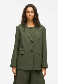 Blazer ajusté vert olive en tissu structuré, avec un col cranté, une fermeture à bouton simple et deux poches avant.