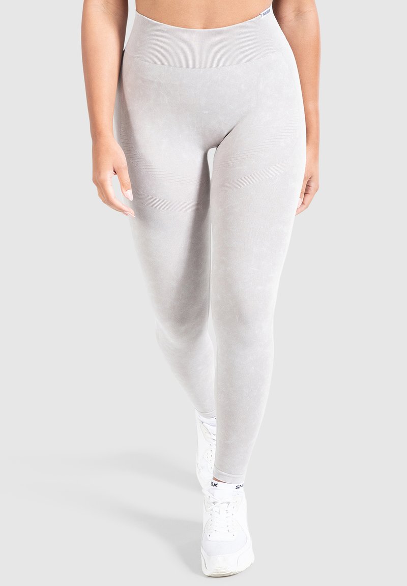 Leggings grigi chiaro realizzati in un tessuto morbido e elasticizzato con una vita alta. Presentano una sottile texture e dettagli a coste in vita.