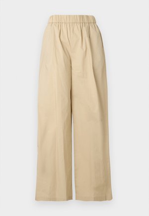 Calças bege de perna larga com cintura elástica, frente lisa e textura de tecido suave. Apresentam um corte folgado para maior conforto.