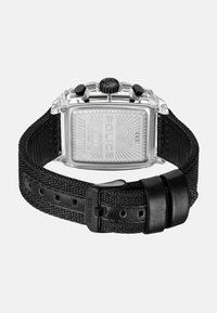 Orologio quadrato in metallo con cassa argentata, cinturino nero texturizzato e dettagli con logo. Presenta diversi pulsanti e un retro decorato.