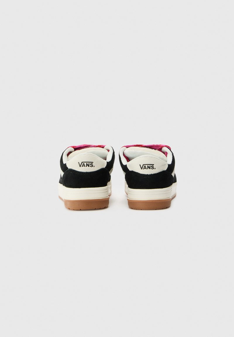 Zapatillas de ante negro con una media suela blanca y suela exterior de goma marrón. Forro rosa visible en el interior. Logo "VANS." en la etiqueta del talón trasero.