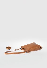 Braune Leder-Crossbody-Tasche mit weicher Textur, verstellbarem Gurt und seitlichen Schnallen. Sie verfügt über einen Reißverschluss und einen abnehmbaren Gurt.