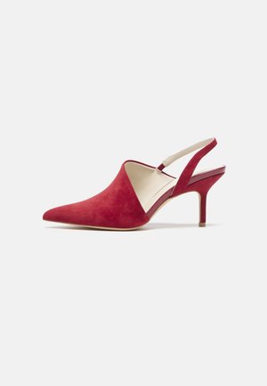Czerwony zamszowy czółenek na obcasie typu slingback z szpiczastym noskiem, z wąskim, średniej wysokości obcasem i beżową podszewką na białym tle.