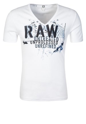 T-shirt blanc à col en V avec un graphisme abstrait noir et bleu et un texte en gras "RAW untreated unprocessed unrefined."