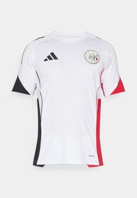 Maillot de sport blanc avec des accents noirs et rouges, à manches courtes et col rond. Comprend un logo sur le devant. Fabriqué en matériau respirant.