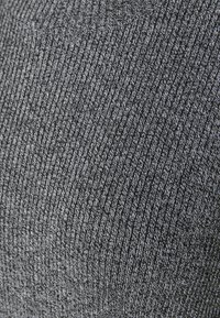 Grå ribbad tyg med en texturerad väv, med tunna vita trådar invävda för kontrast och visuell intresse.