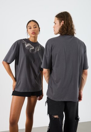 Graues, übergroßes T-Shirt mit einem Schlangendesign auf der Vorderseite. Kurze Ärmel und eine lockere Passform, aus weichem Baumwollmaterial gefertigt.