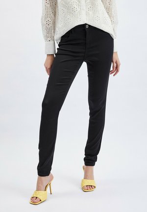 DESIGN - Pantaloni dritti in pelle sintetica nero lucido con borchie