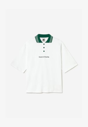 Polo blanc avec col et boutons verts, manches courtes, et texte brodé "Humans Are Exhausting" sur la poitrine.