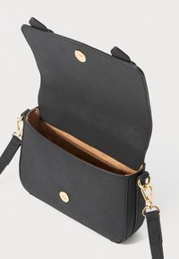 Schwarze Umhängetasche mit goldenem Verschluss und Beschlägen, offenem Klappdeckel, der das tanfarbene Innenleben und die Innentasche mit "Love Moschino"-Etikett zeigt.